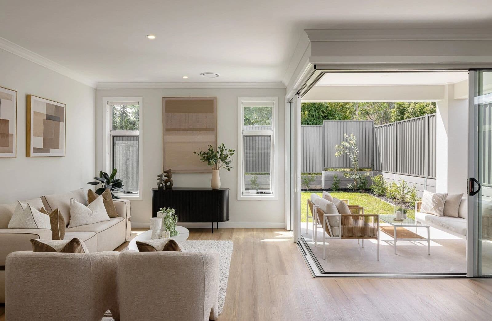 Bright, modern living room styled by RitZi Stagings, opening to a cozy outdoor patio with garden views.